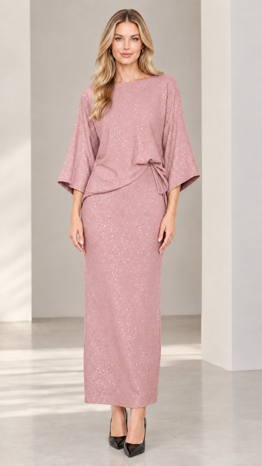 Full-length studio shot of woman wearing dusty pink shimmer top and maxi skirt set