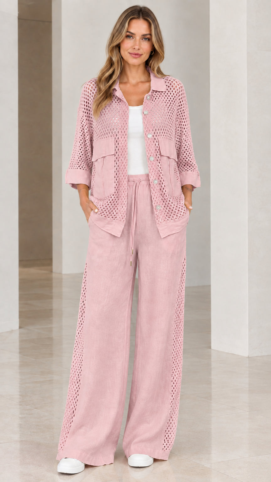 Full front view of woman wearing blush pink open knit shirt and wide-leg pants set