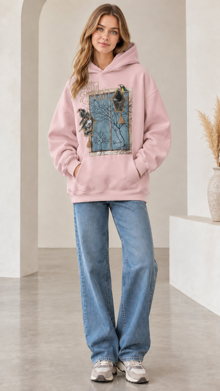 Front view of woman wearing light pink vintage nature bird graphic hoodie