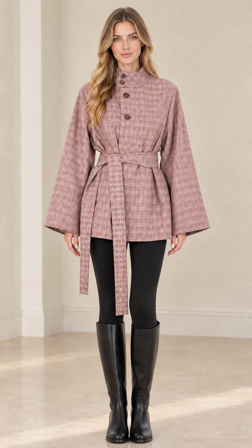 Front view of woman wearing dusty pink plaid belted cape jacket