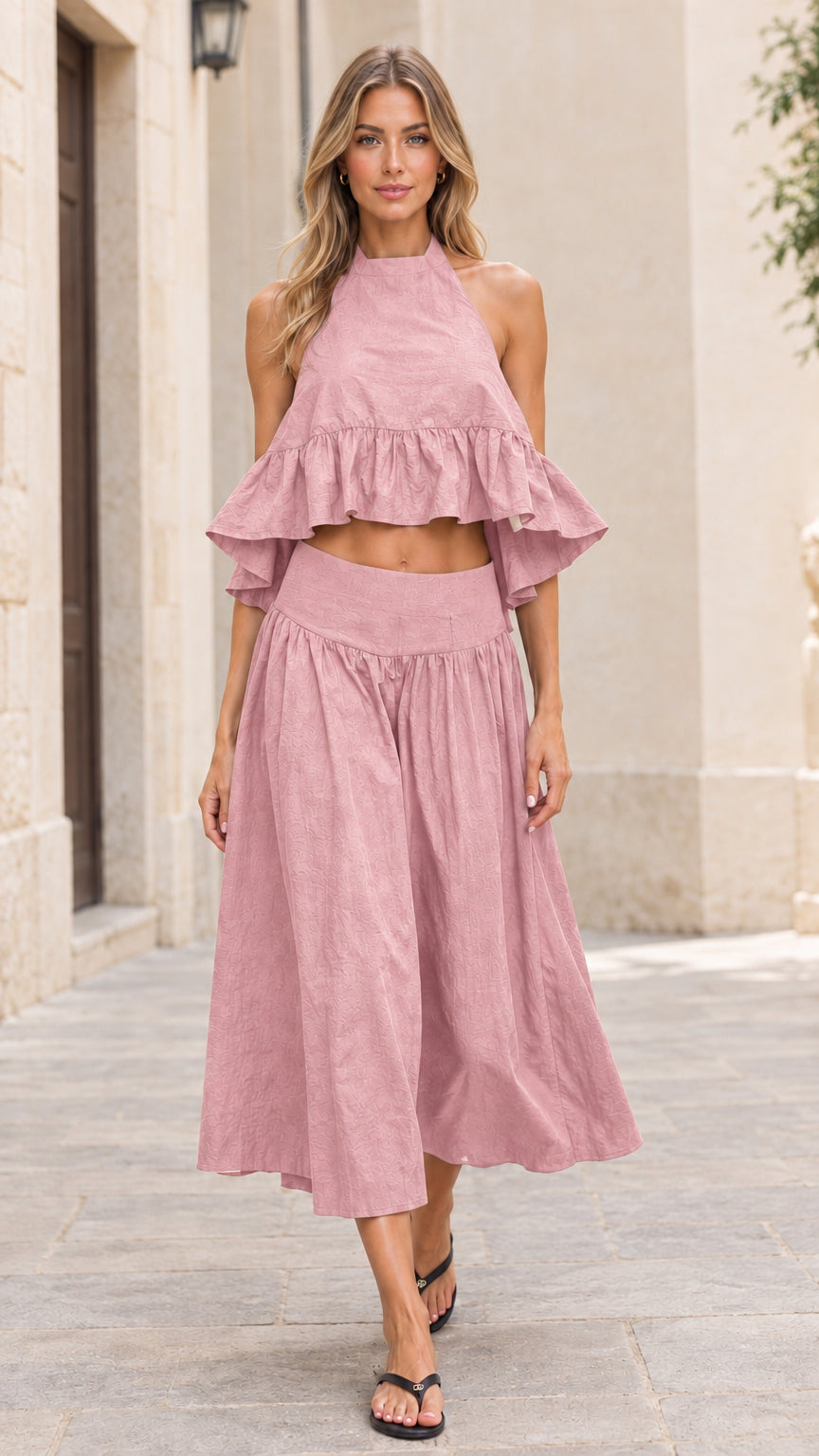 Front full-length view of model wearing dusty pink halter crop top and midi skirt set
