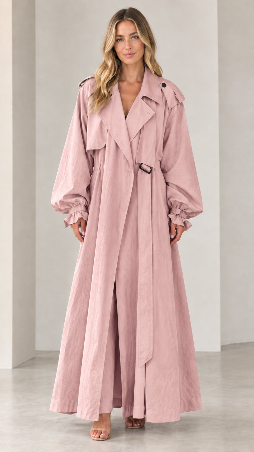 Front view of woman wearing full-length blush pink belted maxi trench coat