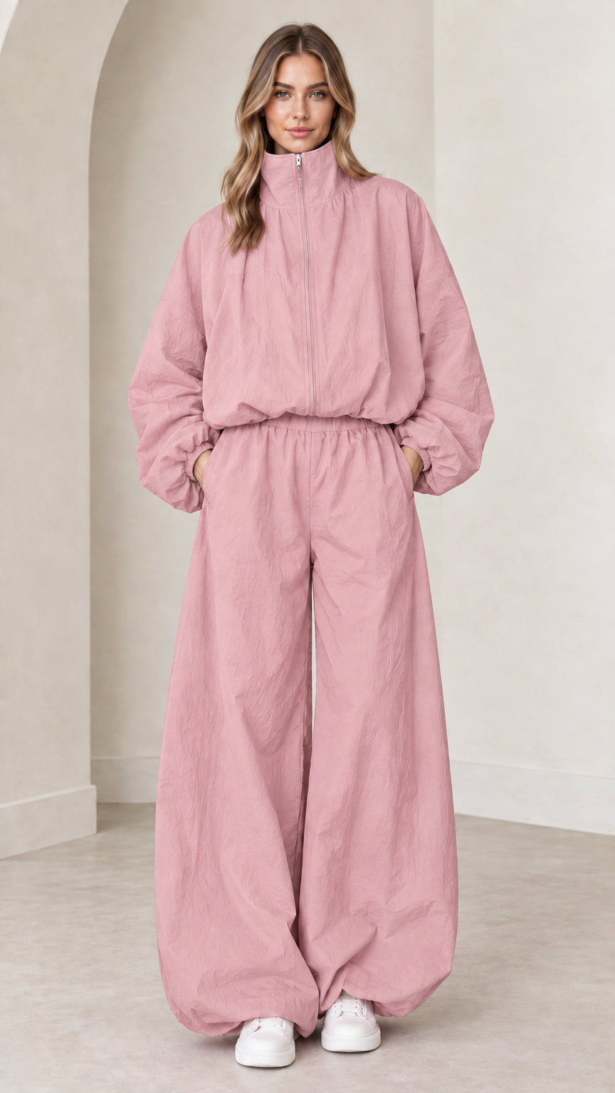 Model wearing dusty pink zip-up parachute jumpsuit with relaxed wide legs