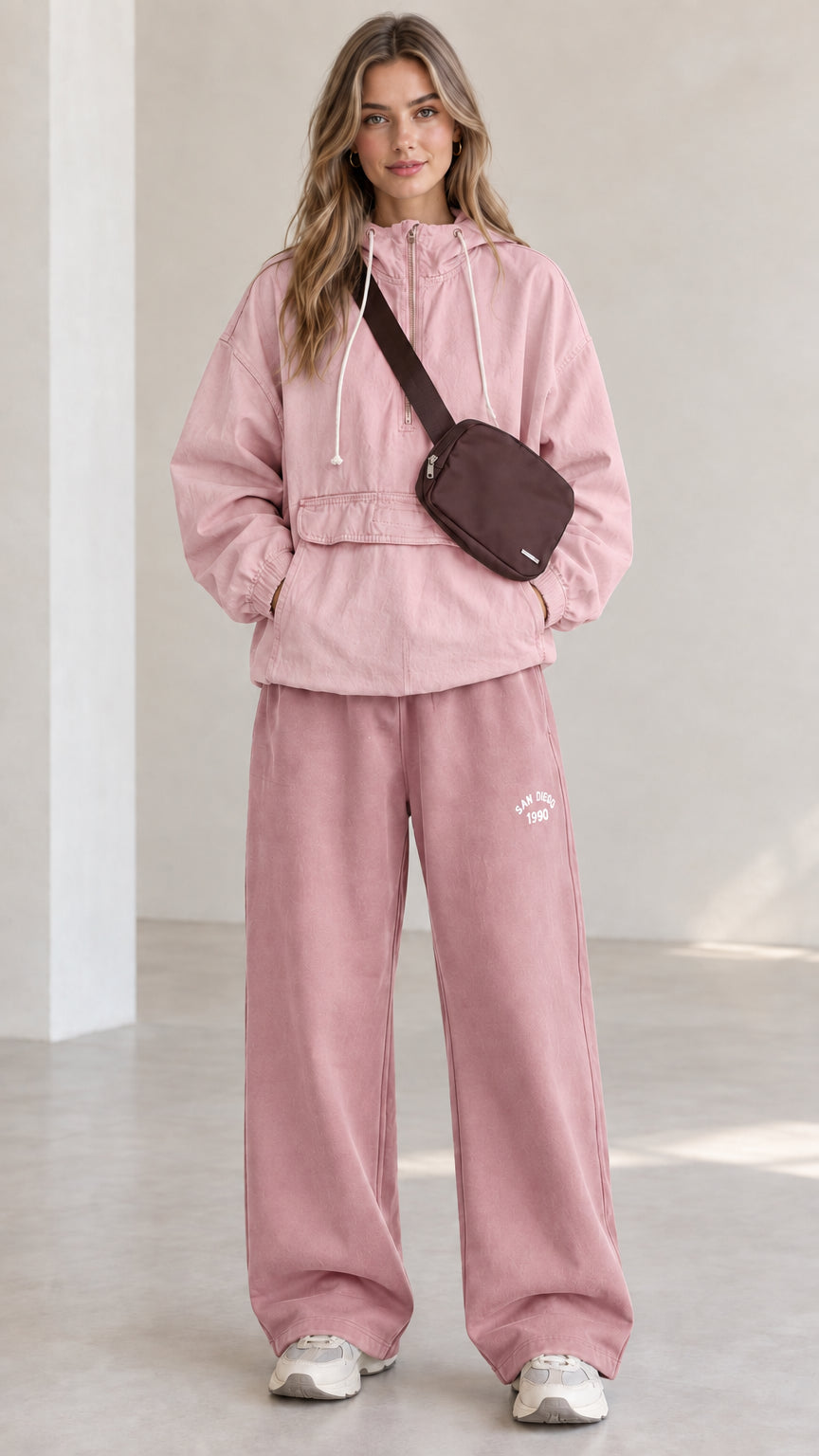 Full-length front view of model wearing pink half-zip hooded anorak jacket