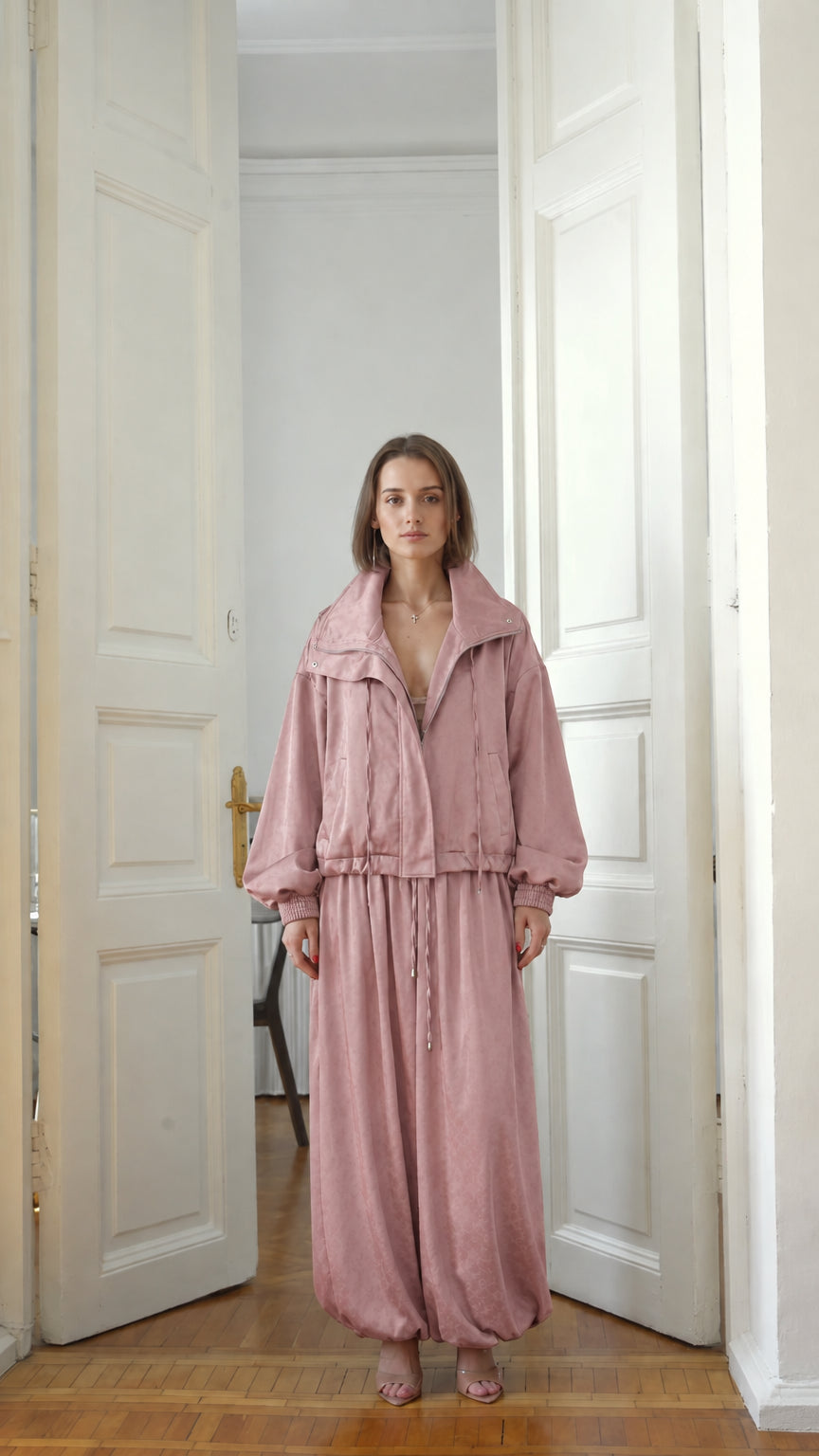 Front view of model wearing dusty pink matching zip-up jacket and relaxed pants set