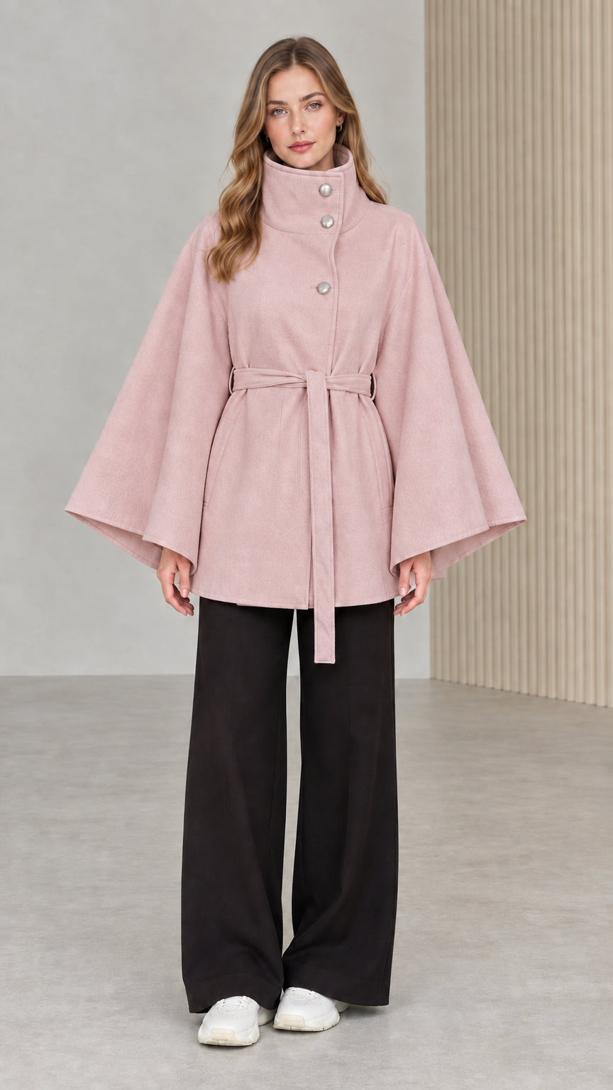 Front view of model wearing dusty pink high neck belted cape coat