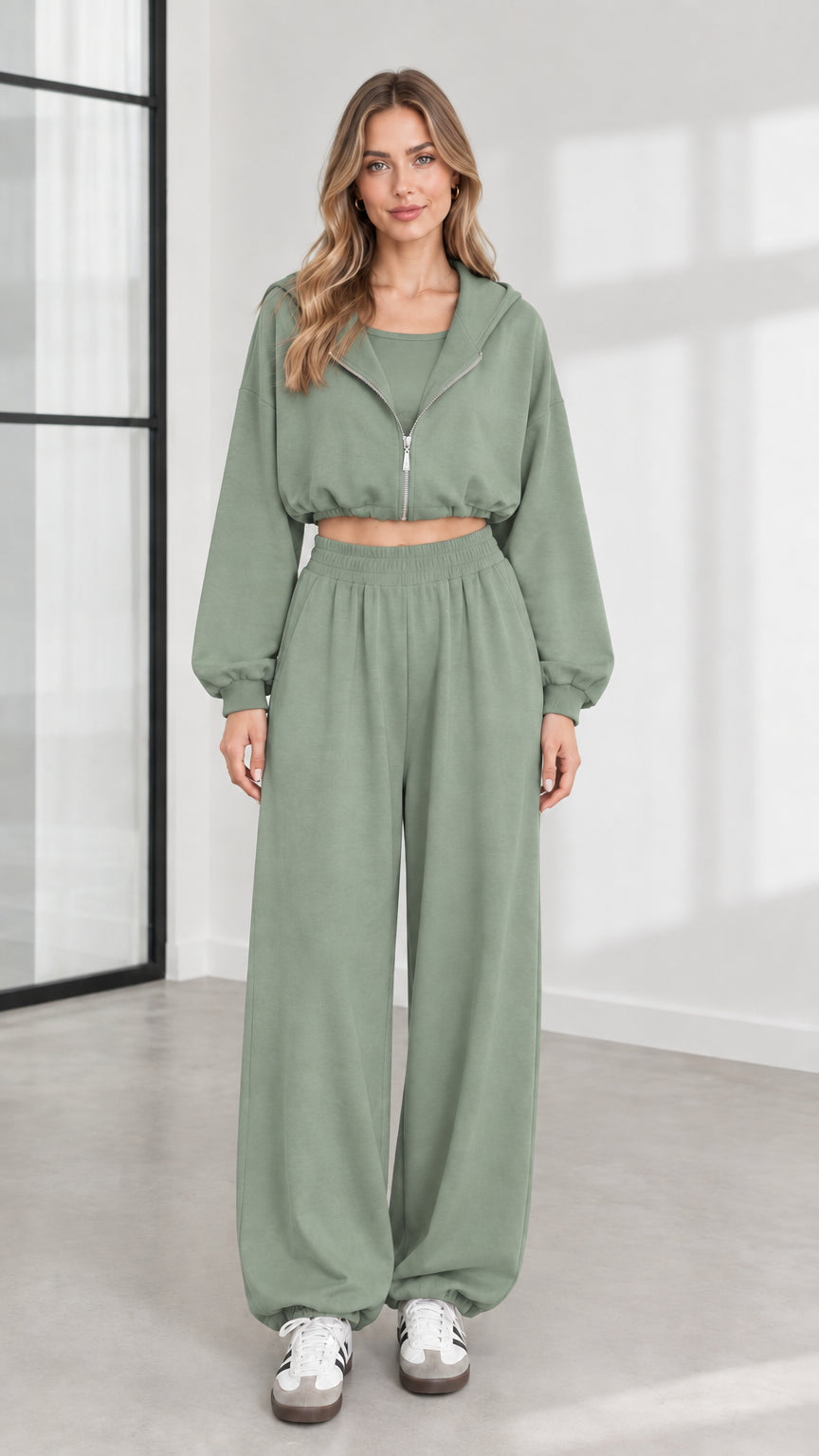 Front view of model wearing sage green 3-piece cropped zip hoodie and wide-leg sweatpants