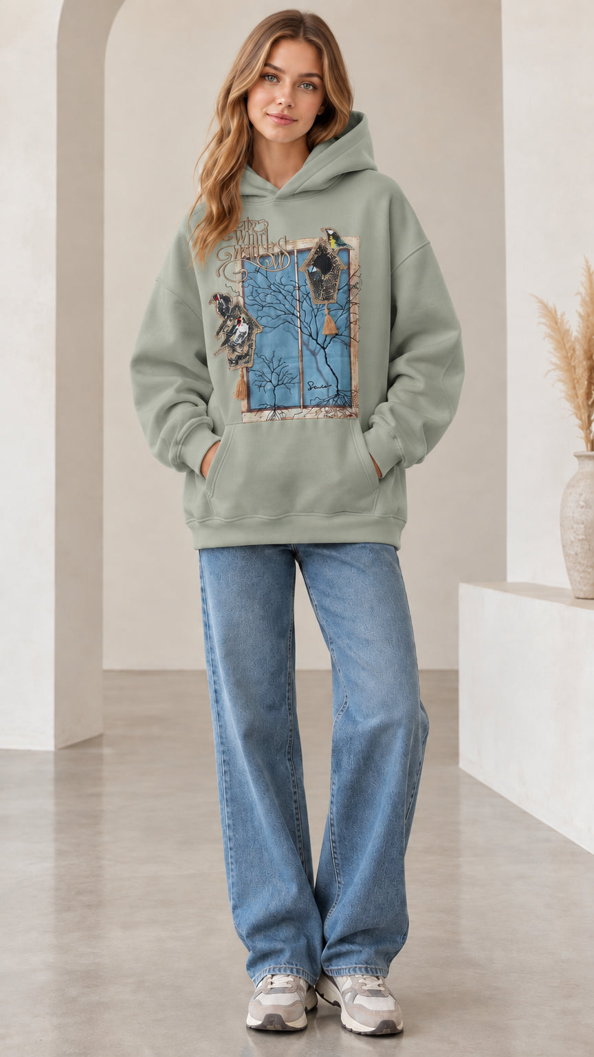 Front view of woman wearing sage green vintage nature bird graphic hoodie