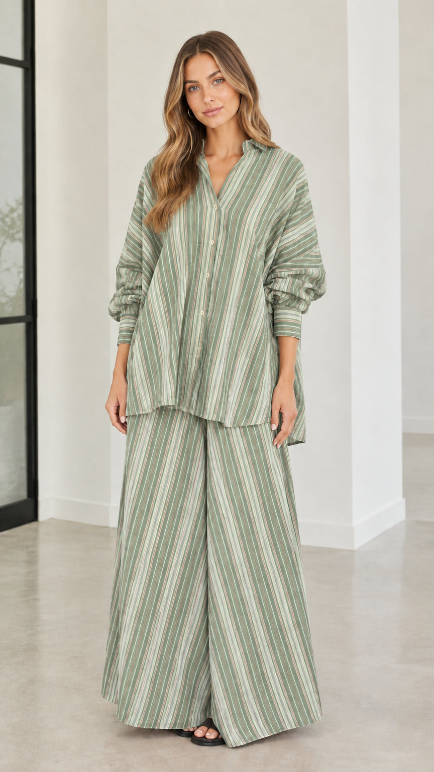 Model wearing sage green and white striped two-piece shirt and wide-leg pant set