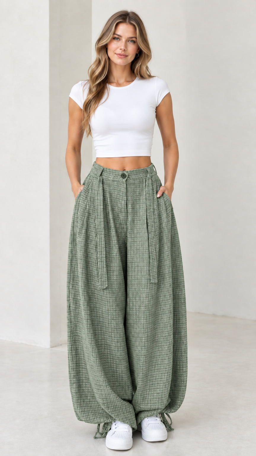 Front view of woman wearing sage green micro-plaid pleated wide leg pants