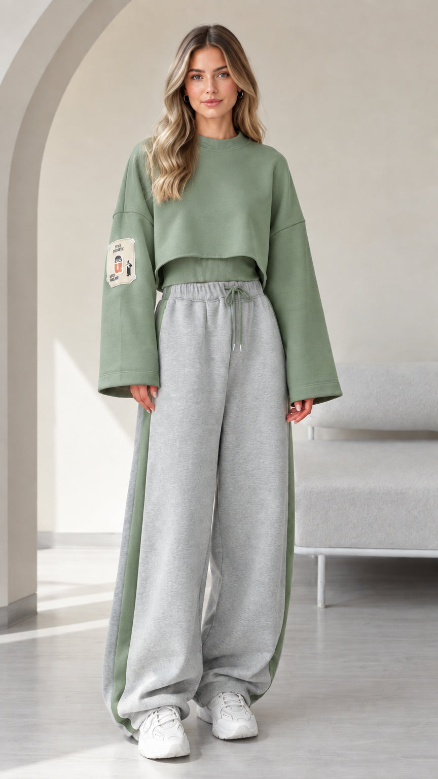 Model wearing sage green cropped sweatshirt and grey wide leg sweatpants with green side stripe