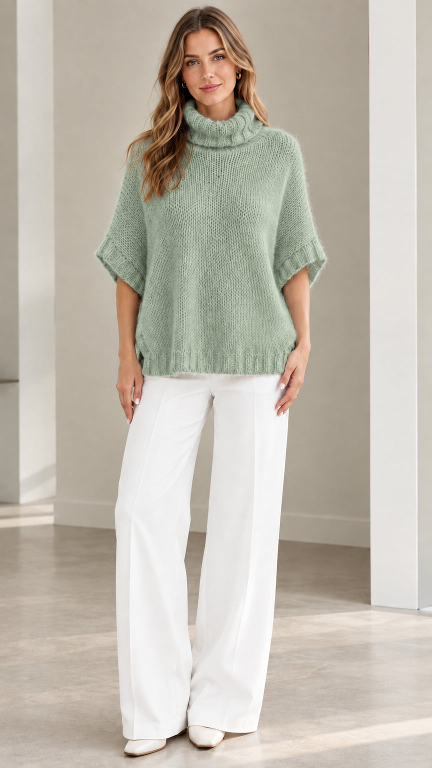 Model wearing Sage Green fuzzy turtleneck poncho sweater