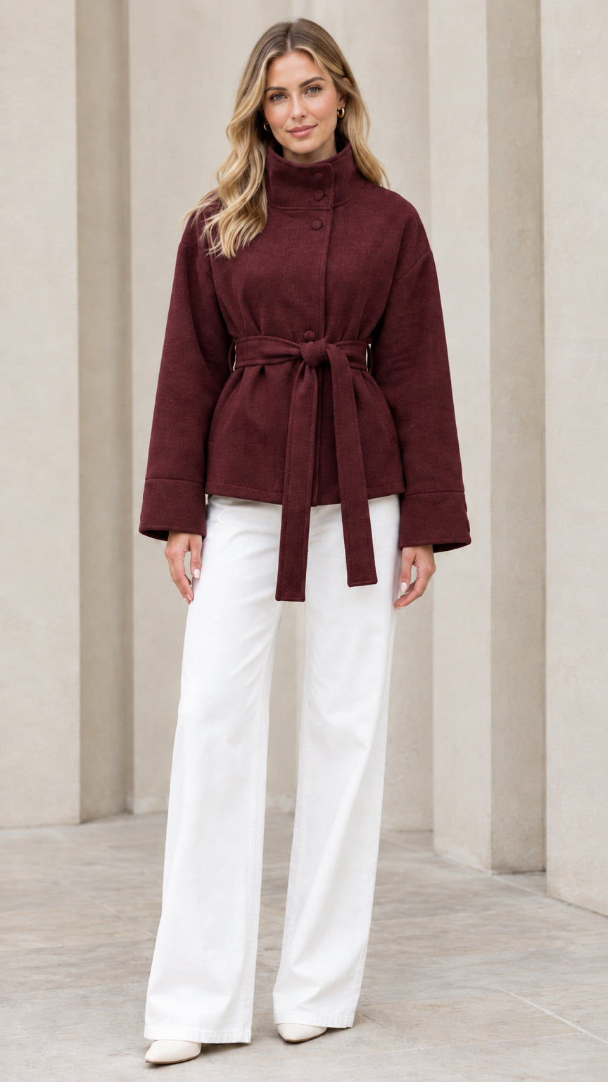 Front view of model wearing burgundy stand collar belted short coat