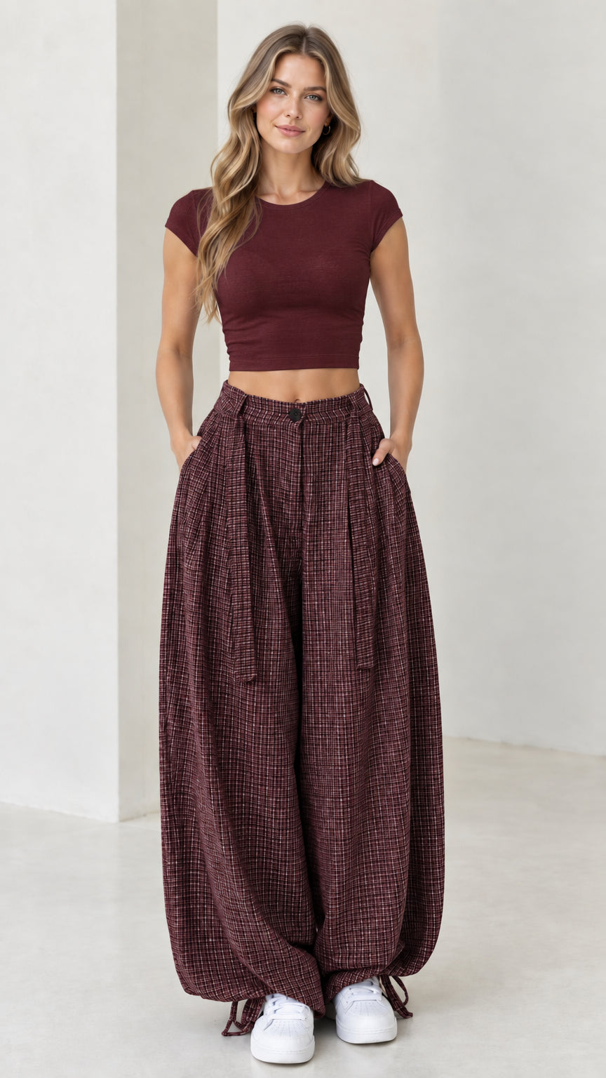 Front view of woman wearing burgundy wine red micro-plaid balloon pants