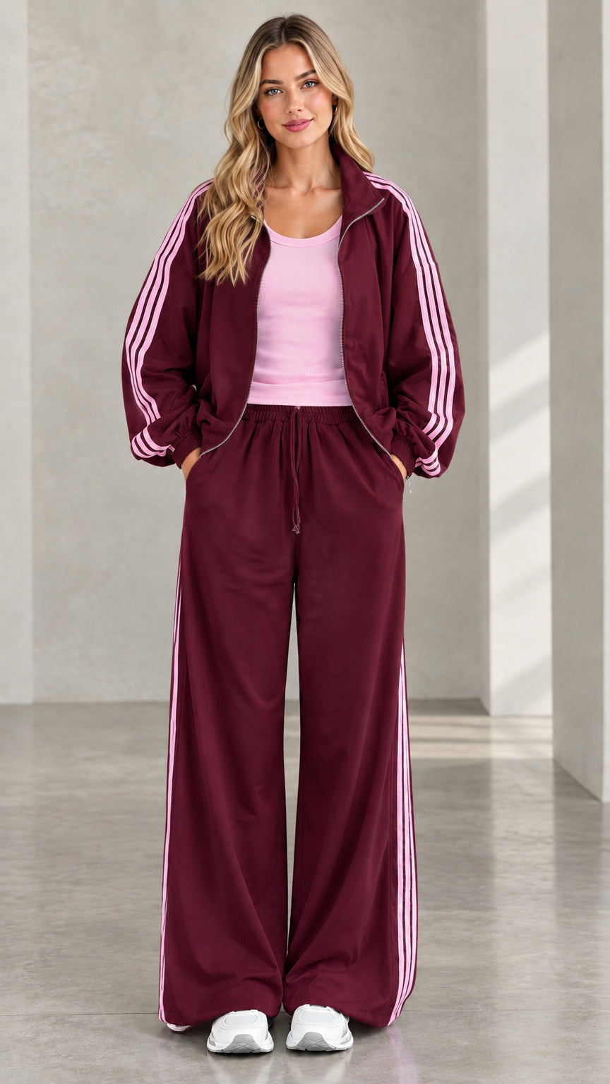 Front view of model wearing burgundy tracksuit set with light pink side stripes