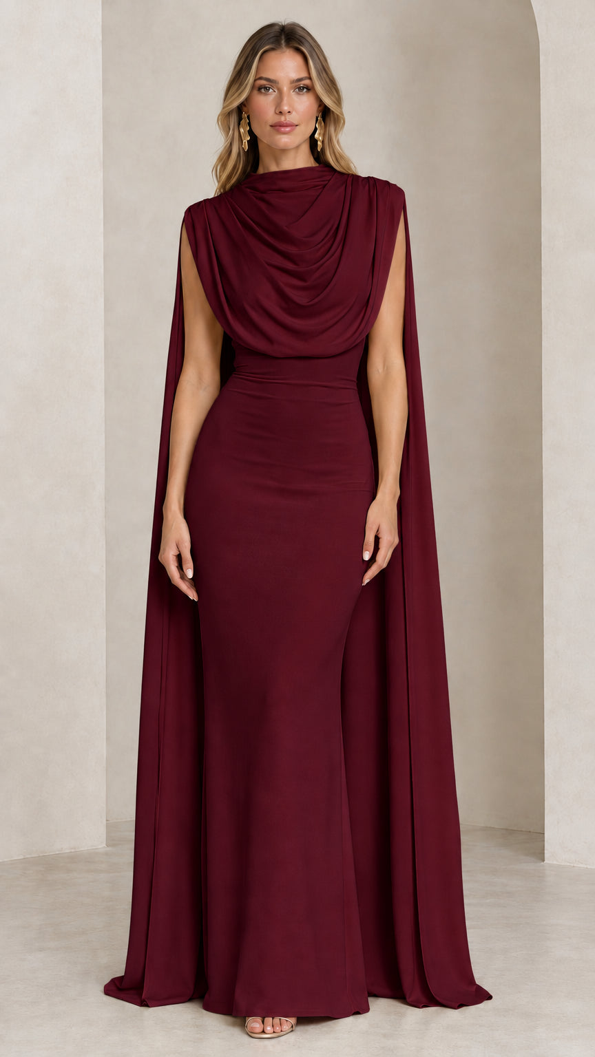 Front view of model wearing the burgundy draped cowl neck cape evening gown