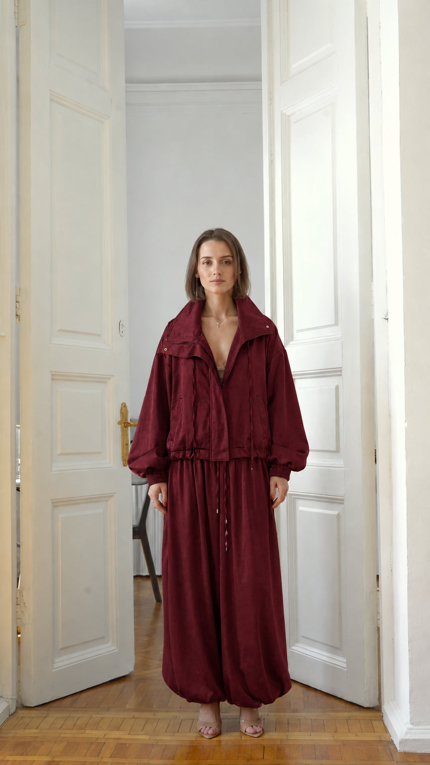 Front view of model wearing burgundy red two-piece jacket and balloon pants set