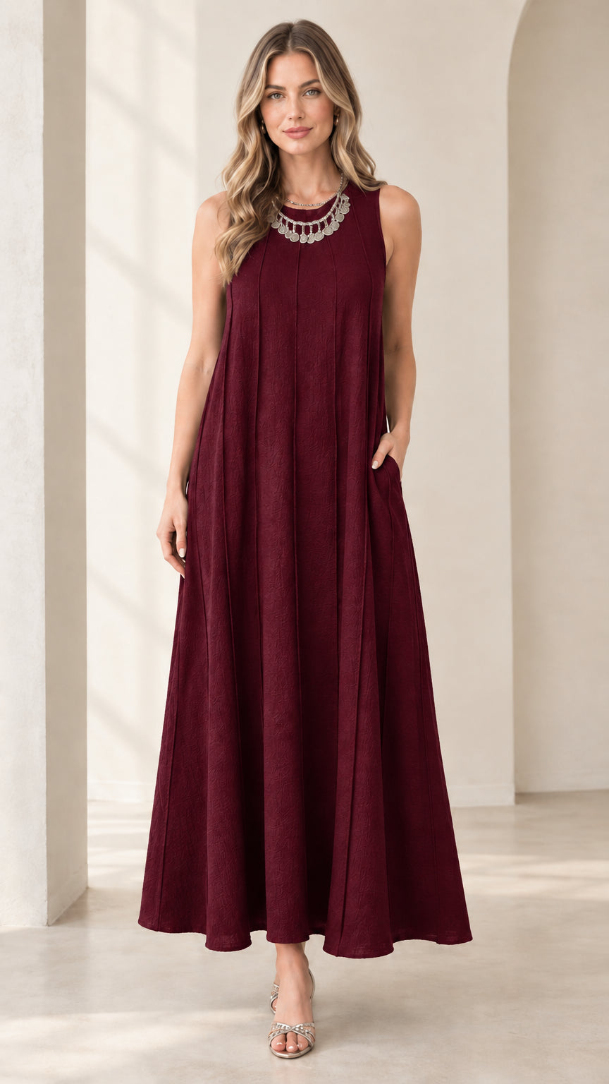 Front view of woman wearing burgundy sleeveless panel swing maxi dress with pockets