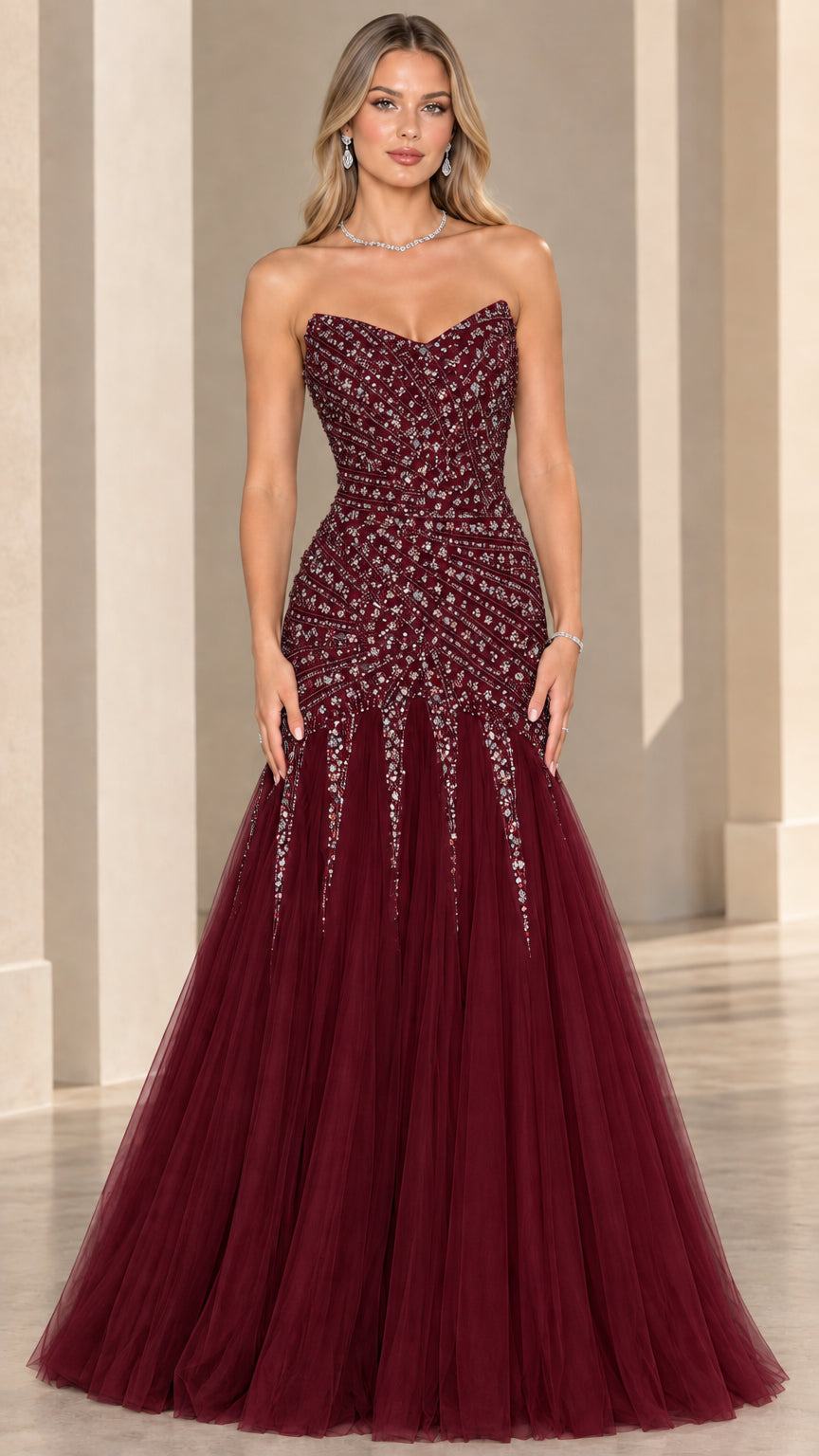 Front view of model wearing burgundy strapless beaded mermaid formal gown