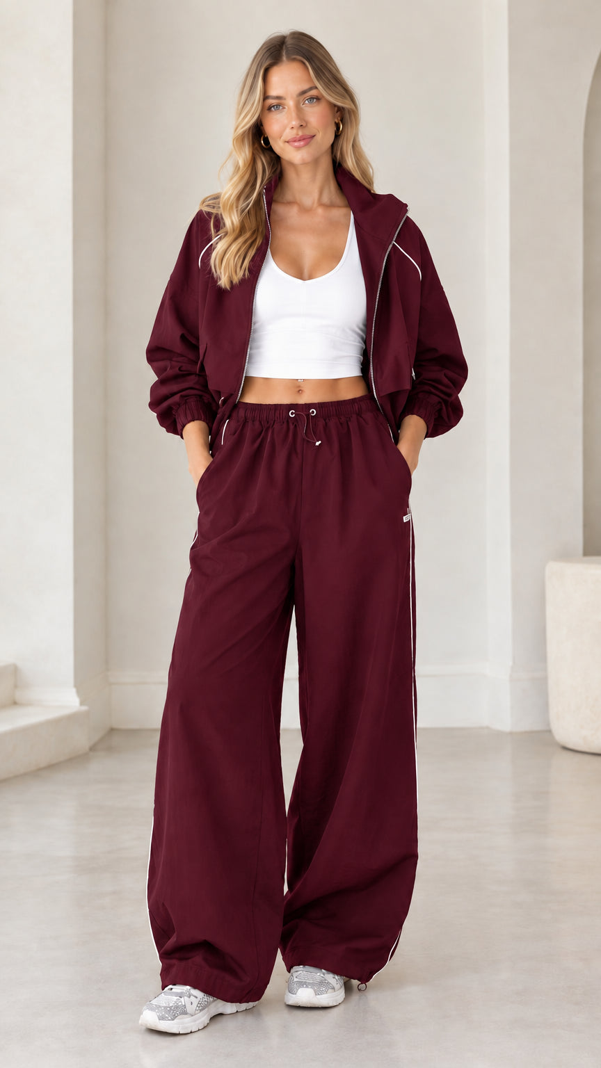 Model wearing burgundy cropped zip jacket and matching wide leg pants set