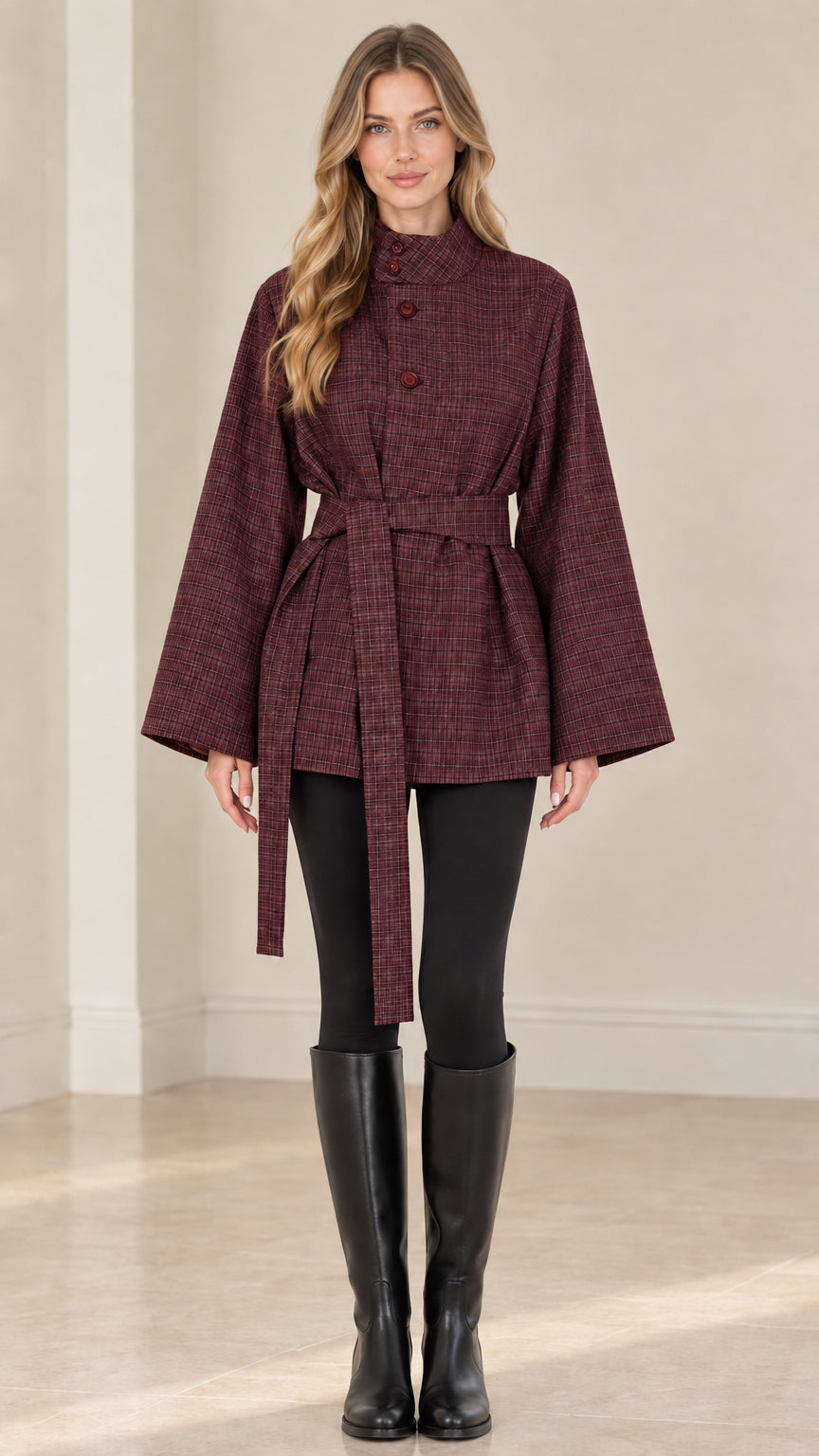 Front view of woman wearing burgundy plaid belted cape jacket