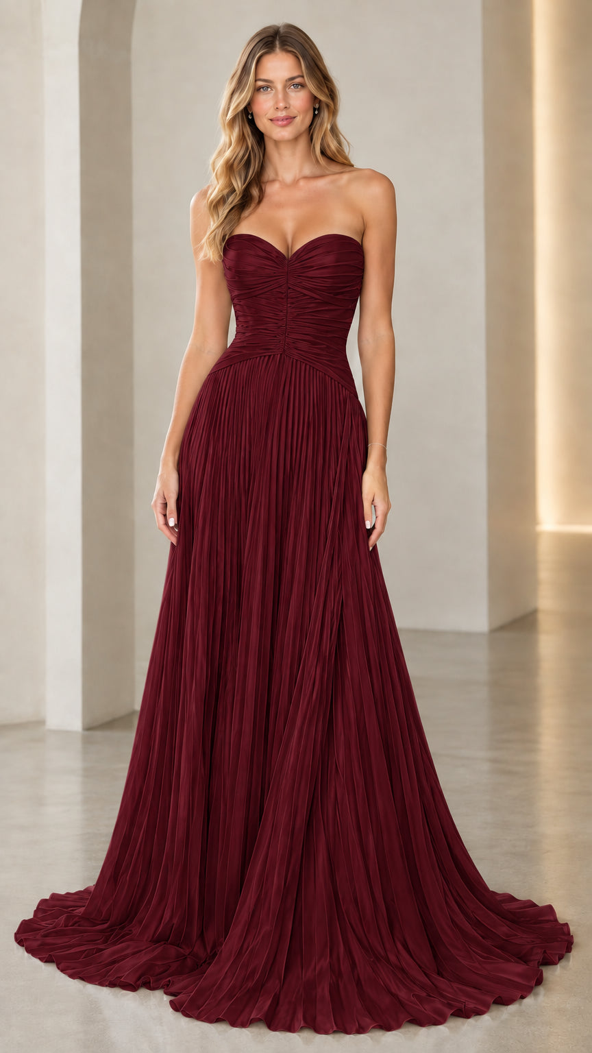 Model wearing burgundy red strapless sweetheart pleated evening dress