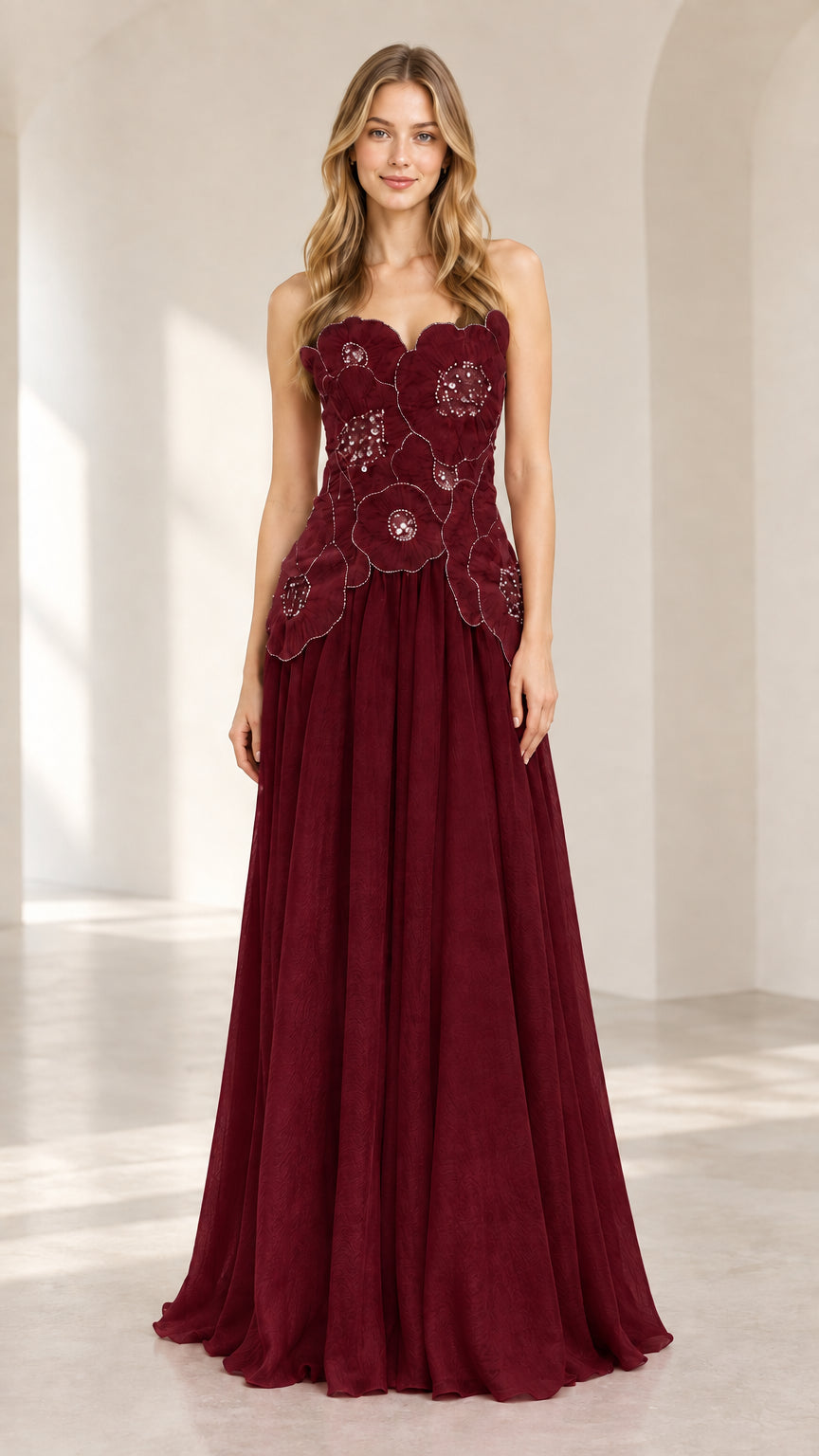 Front view of model wearing burgundy strapless floral chiffon evening gown