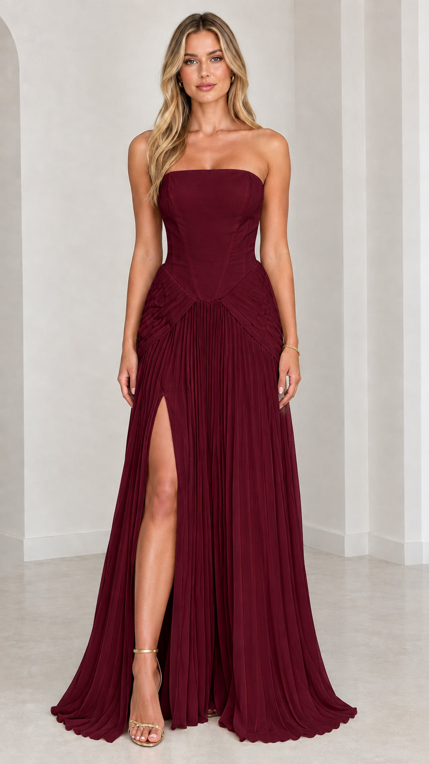 Model wearing burgundy strapless pleated maxi dress with high slit