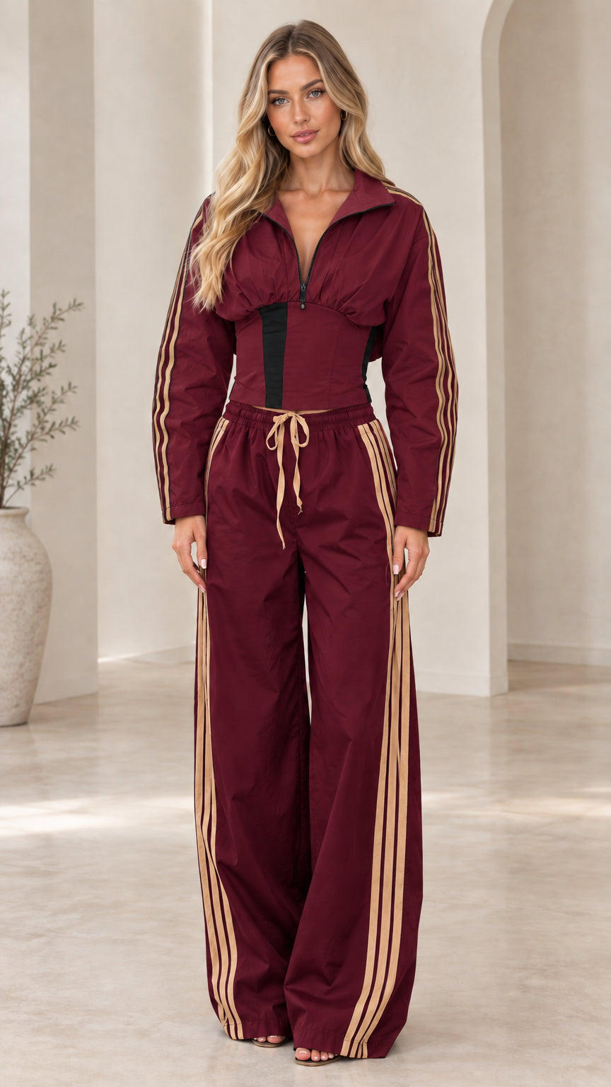 Full-length front view of burgundy zip-up corset jacket and wide-leg track pants set