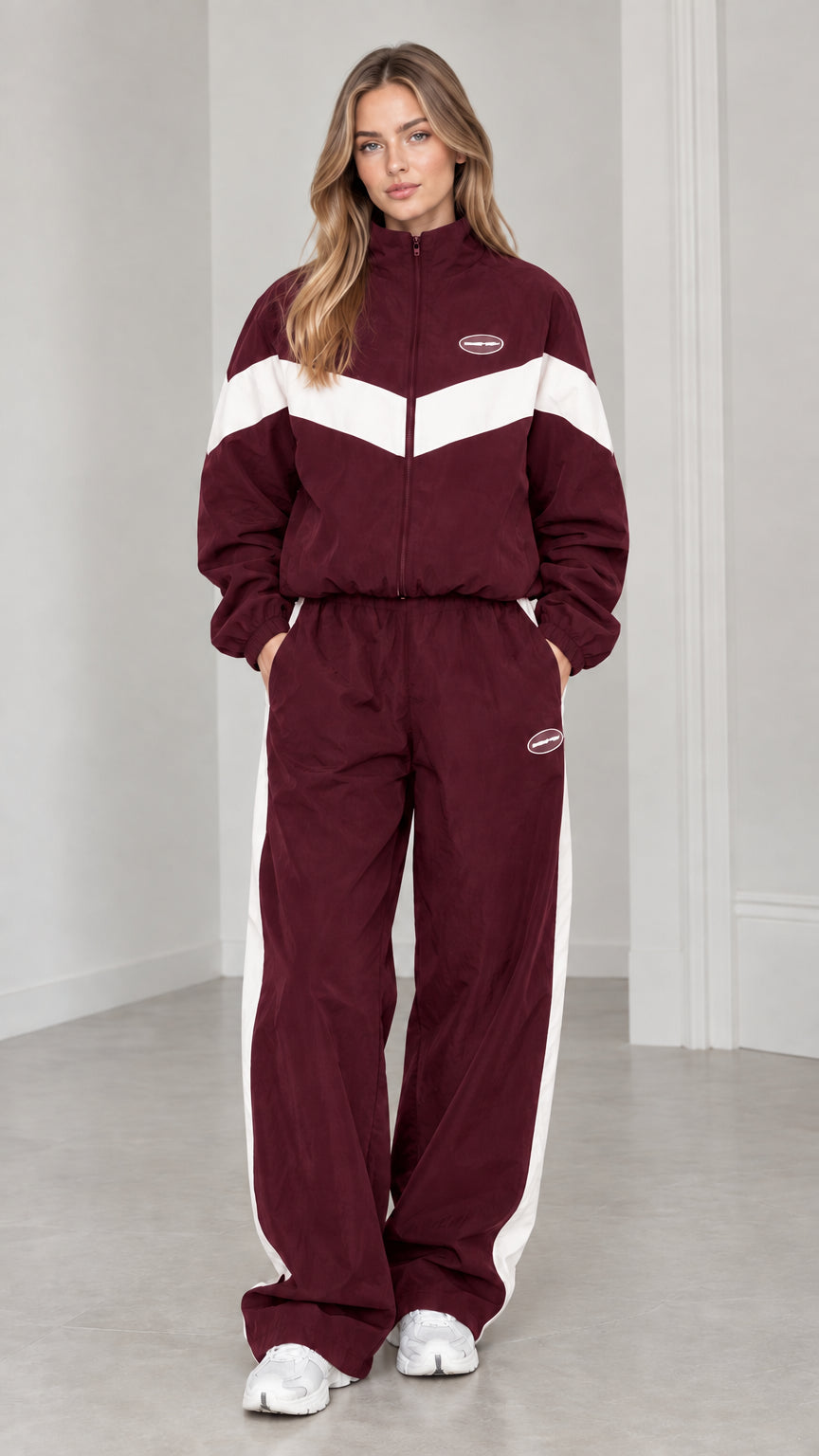 Full length view of woman wearing burgundy and white colorblock tracksuit set