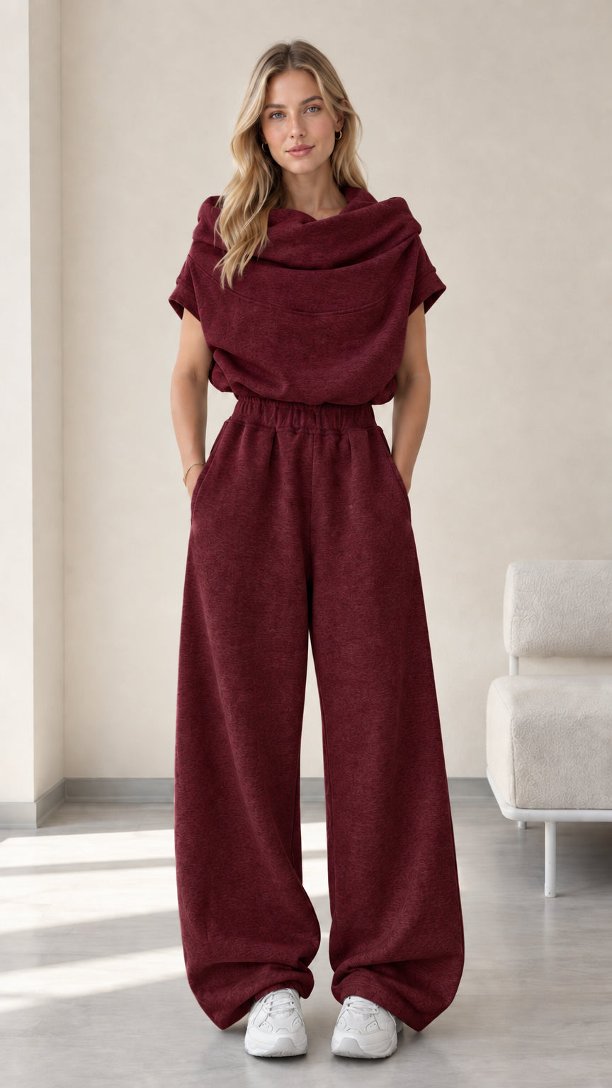 Full-length studio view of model wearing burgundy wine red cowl neck top and wide-leg pants set