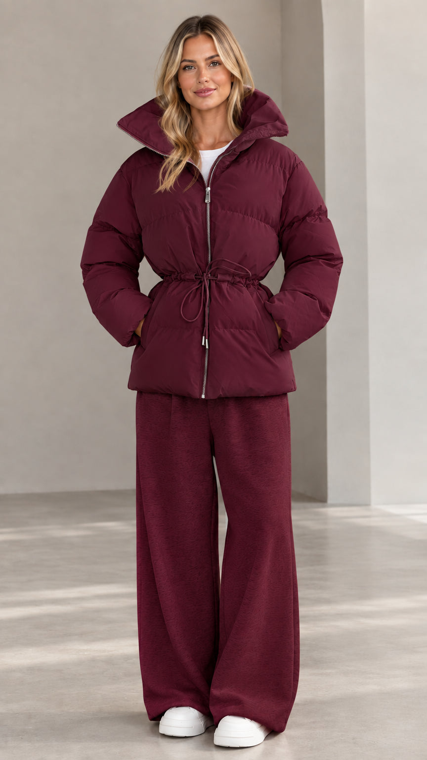 Front view of woman wearing burgundy wine hooded cinch-waist puffer jacket