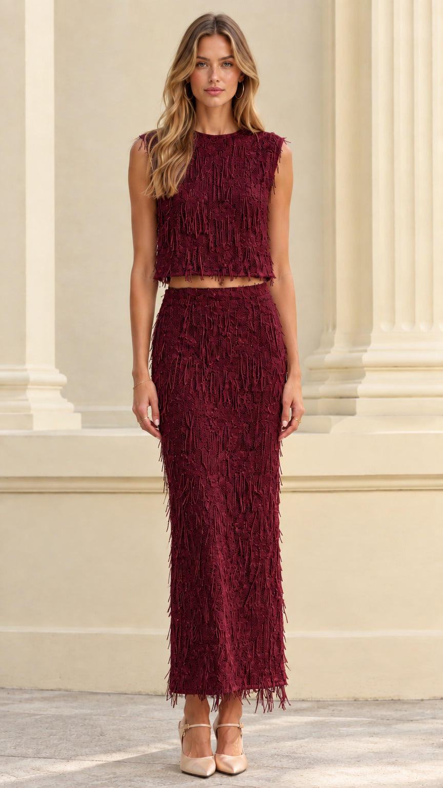 Front full view of woman wearing burgundy textured fringe crop top and maxi skirt set
