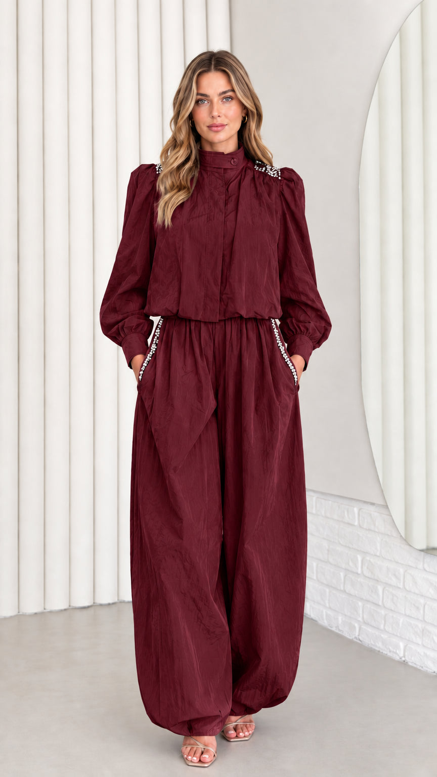 Front view of model wearing burgundy wine-colored rhinestone jumpsuit