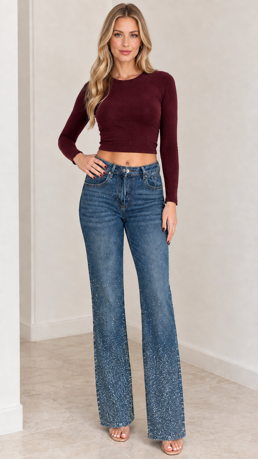 Model wearing rhinestone flare jeans paired with a burgundy long-sleeve crop top