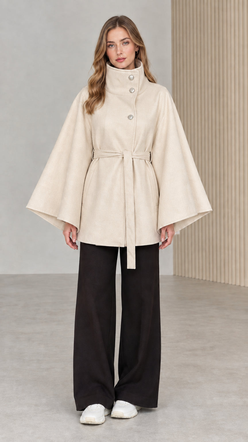 Front view of model wearing cream beige high neck belted cape coat
