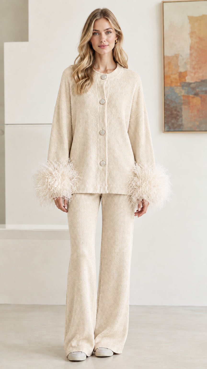 Front view of model wearing cream beige ribbed knit cardigan and pant set with feather cuffs