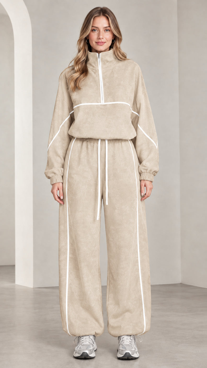 Front view of woman wearing beige quarter-zip tracksuit set with white contrast piping