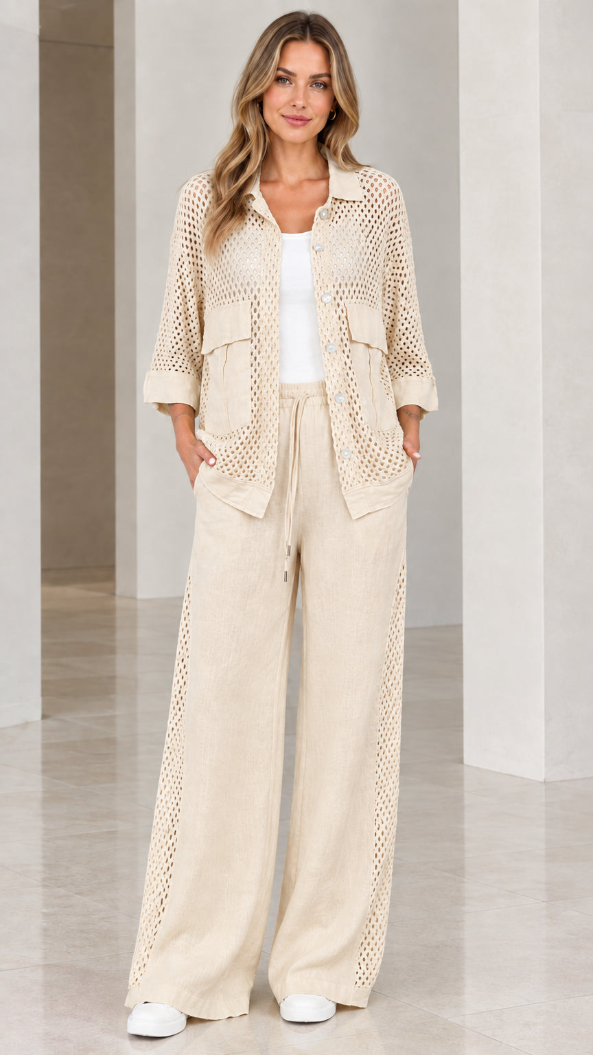Full front view of woman wearing beige cream open knit shirt and wide-leg pants set