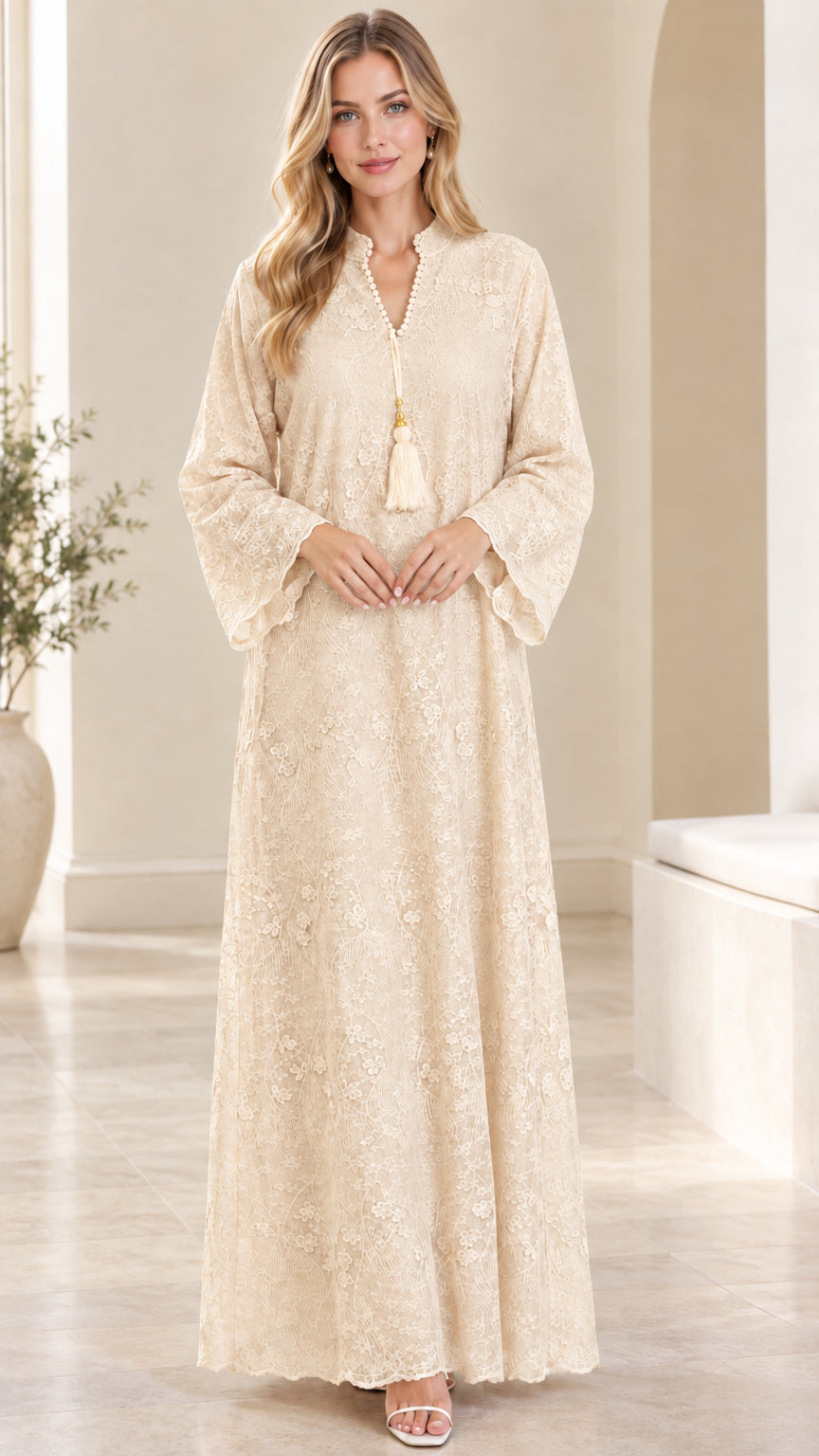 Front view of woman wearing cream beige floral lace maxi dress with tassel trim